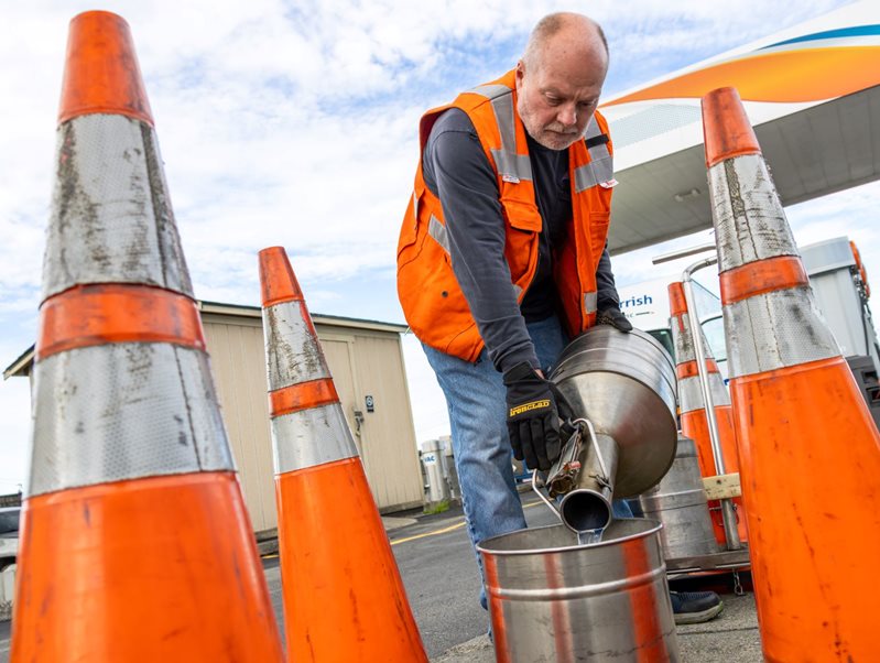 man pouring fuel into an underground tank