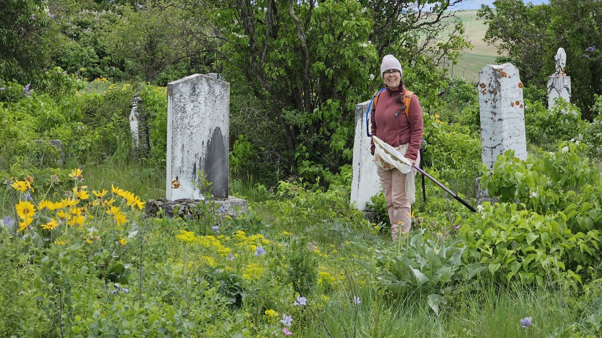 Karen Wright in cemetery with blooming flowers
