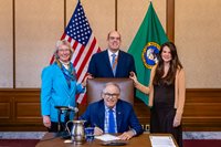 L-R Annette Hoffman, Ken Camp and Trecia Ehrlich pose with Governor Jay Inslee (front).