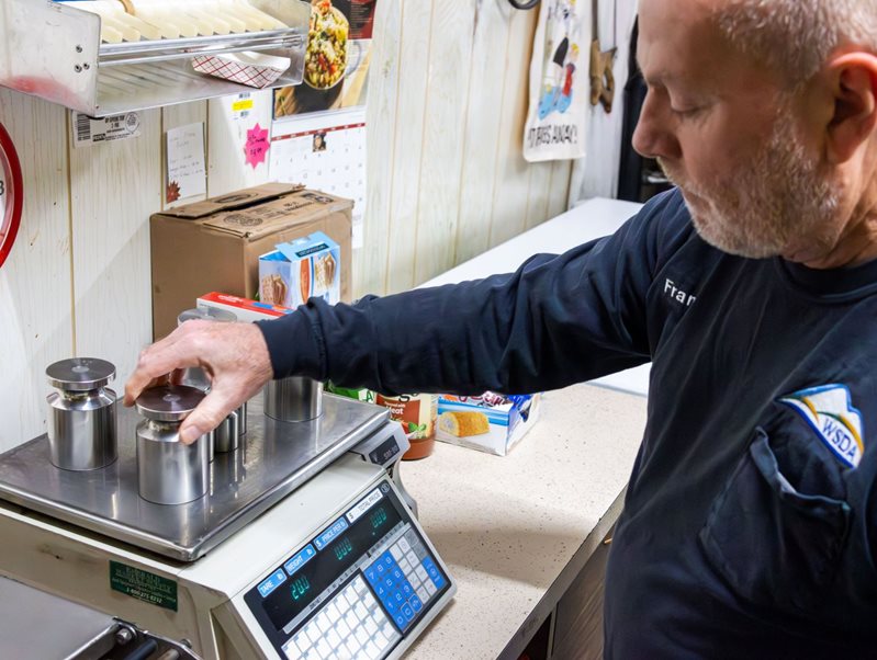 Man placing weights on digital scale