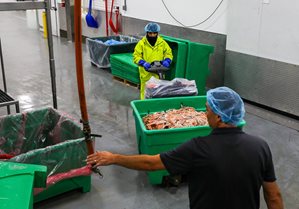 Workers wheel a cart in a warehouse.