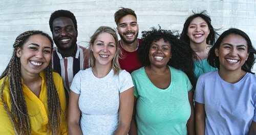 Photo of a group of diverse people standing together and smiling at the camera